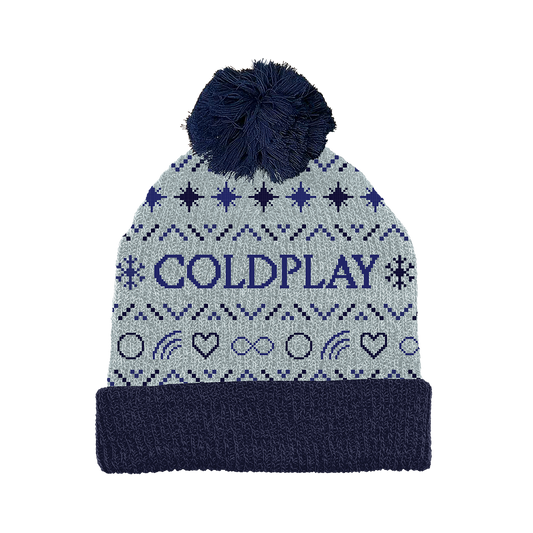 Festive light grey winter beanie, with a fluffy navy blue pom-pom. The word COLDPLAY is prominently displayed in purple letters on the front, surrounded by stars&snowflakes. With infinity symbols, heart outlines,&rainbows in between, all in dark blues&blacks. The black stars form symmetrical rows that repeat throughout. The hat is knitted, and looks very cozy. Its foldOver brim is navy blue, matching the color of the pom-pom, that highlights the fun spirit of the festive season